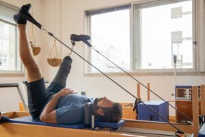 man with prosthetic leg using pilates reformer