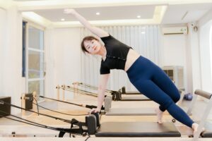 woman using pilates reformer